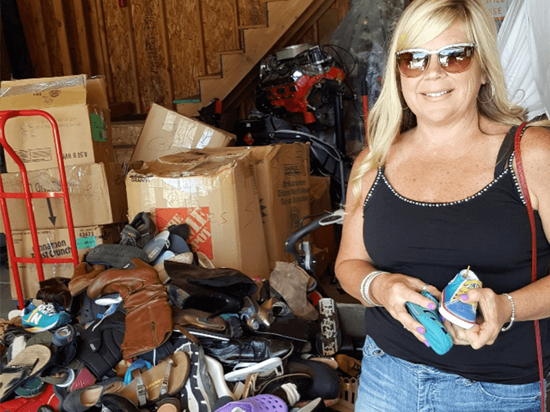 Audrey Ramos showing donated shoes. Brighton Collectibles in Farmington, Utah.